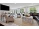 Bright living room with white marble floors, comfortable seating, and a view of the dining area through French doors at 805 Bannockburn Ave, Temple Terrace, FL 33617