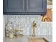 Detailed view of a wet bar with brass faucet and hardware, geometric backsplash and under cabinet lighting at 805 Bannockburn Ave, Temple Terrace, FL 33617
