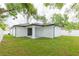 Expansive backyard with a covered patio and lush green grass, perfect for outdoor activities and relaxation at 907 E Okaloosa Ave, Tampa, FL 33604