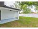 Spacious backyard featuring a covered patio, lush green grass, and a white privacy fence at 907 E Okaloosa Ave, Tampa, FL 33604