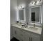 Bathroom featuring double vanity sinks, backlit mirrors, modern lighting, and elegant hardware at 907 E Okaloosa Ave, Tampa, FL 33604