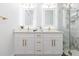 Bathroom featuring double sinks, stylish mirrors and a glass enclosed shower at 907 E Okaloosa Ave, Tampa, FL 33604