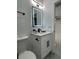 Bathroom featuring a vanity sink, backlit mirror, modern fixtures, and minimalist design at 907 E Okaloosa Ave, Tampa, FL 33604