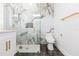 Sleek bathroom showcasing marble-look shower with gold fixtures, floating vanity, and modern toilet at 907 E Okaloosa Ave, Tampa, FL 33604