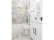 Bathroom with a tub, modern fixtures, vanity, and stylish marble-look tile accents at 907 E Okaloosa Ave, Tampa, FL 33604