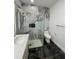 Stylish bathroom showcasing marble-like shower tiling, gold accents, and contemporary fixtures at 907 E Okaloosa Ave, Tampa, FL 33604