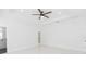 Bright bedroom features white walls, tile floors, modern ceiling fan and door leading to the bathroom at 907 E Okaloosa Ave, Tampa, FL 33604
