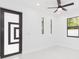 Bright bedroom featuring modern door, neutral walls, and elegant ceiling fan at 907 E Okaloosa Ave, Tampa, FL 33604