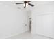 Bedroom with white walls, tile floors, ceiling fan and closet offering a clean and neutral space at 907 E Okaloosa Ave, Tampa, FL 33604