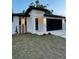 Contemporary home featuring a modern design, clean lines, a black garage door and manicured lawn at 907 E Okaloosa Ave, Tampa, FL 33604