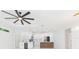 Open kitchen featuring white cabinetry, marble backsplash, island, and modern ceiling fan at 907 E Okaloosa Ave, Tampa, FL 33604