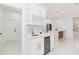 Kitchen area with sink, white cabinets, wine rack, marble backsplash, and a built-in wine cooler at 907 E Okaloosa Ave, Tampa, FL 33604