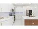 Bright kitchen featuring white cabinetry, gold hardware, marble backsplash, and kitchen island at 907 E Okaloosa Ave, Tampa, FL 33604