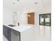 Open kitchen showcasing modern pendant lights, quartz countertops and gray lower cabinets at 907 E Okaloosa Ave, Tampa, FL 33604