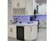 Kitchen featuring a wine rack, elegant white cabinets, quartz countertops, and modern gold hardware at 907 E Okaloosa Ave, Tampa, FL 33604