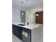 Modern kitchen island with a sink, dishwasher, white countertops and navy blue cabinets at 907 E Okaloosa Ave, Tampa, FL 33604