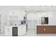 Bright kitchen featuring white cabinetry, gold hardware, marble backsplash, and an island at 907 E Okaloosa Ave, Tampa, FL 33604