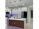 Bright kitchen showcasing white cabinets, a stylish island with a wooden accent, and modern pendant lighting at 907 E Okaloosa Ave, Tampa, FL 33604