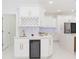 Kitchen area with white cabinets, wine rack, marble backsplash, and a built-in wine cooler at 907 E Okaloosa Ave, Tampa, FL 33604