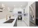 Modern kitchen with an island, pendant lights, white cabinets, and stainless steel appliances at 907 E Okaloosa Ave, Tampa, FL 33604