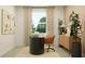 Well-lit home office featuring a sleek desk, ergonomic chair, and serene garden view at 9582 Runaway Breeze Dr, Land O Lakes, FL 34637