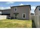 Fenced backyard features a well-maintained lawn, sliding door, and grill at 9616 Lemon Drop Loop, Sun City Center, FL 33573