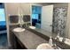 Bathroom with double sink, granite countertops, and shower at 9616 Lemon Drop Loop, Sun City Center, FL 33573