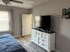Cozy bedroom featuring a white dresser, a television, and a window with blinds at 9616 Lemon Drop Loop, Sun City Center, FL 33573