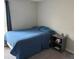 Well lit bedroom featuring a bed with blue comforter and side table at 9616 Lemon Drop Loop, Sun City Center, FL 33573