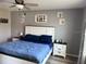 Well-lit bedroom with a bed, bedside tables, and decorative wall art at 9616 Lemon Drop Loop, Sun City Center, FL 33573