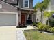 Two-story home featuring manicured garden, front lawn and front porch seating at 9616 Lemon Drop Loop, Sun City Center, FL 33573