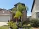 Home showcasing manicured garden, palm trees and a two car garage at 9616 Lemon Drop Loop, Sun City Center, FL 33573