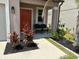 Charming front porch sitting area enhanced by a well manicured garden at 9616 Lemon Drop Loop, Sun City Center, FL 33573