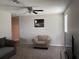 Bright living room featuring neutral carpeting, a comfortable sofa chair, and a ceiling fan at 9616 Lemon Drop Loop, Sun City Center, FL 33573