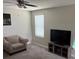 Well-lit living room with a beige sofa chair, neutral carpet, and a ceiling fan at 9616 Lemon Drop Loop, Sun City Center, FL 33573