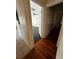 View of hallway and bedroom featuring hardwood floors, ceiling fan, and a black accent rug at 10803 N Florence Ave, Tampa, FL 33612