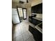 Kitchen featuring black cabinetry and a view into the next room at 10803 N Florence Ave, Tampa, FL 33612