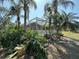Landscaped backyard with a screened-in pool and tropical foliage at 1145 Riveredge Dr, Tarpon Springs, FL 34689