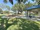 View of playground equipment, benches, and pavilion with grill at 1145 Riveredge Dr, Tarpon Springs, FL 34689