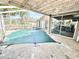 Pool area with damaged screen and a covered pool and patio for outdoor relaxation at 1145 Riveredge Dr, Tarpon Springs, FL 34689