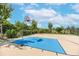 Community basketball court with blue accent paint, basketball hoop and net, surrounded by a black fence at 11606 Kilkenny Coral Dr, Riverview, FL 33579