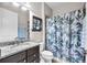 Bathroom featuring a dark vanity, granite countertop, neutral walls, and a shower/tub with decorative curtain at 11606 Kilkenny Coral Dr, Riverview, FL 33579