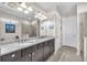Bathroom boasts a double vanity with granite countertops and modern fixtures, plus a tiled glass shower at 11606 Kilkenny Coral Dr, Riverview, FL 33579