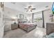 Cozy bedroom with a ceiling fan, neutral decor, and a large window providing ample natural light at 11606 Kilkenny Coral Dr, Riverview, FL 33579