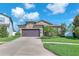 Charming single Gathering home featuring a two-car garage, landscaping, and a well-manicured lawn under a blue sky at 11606 Kilkenny Coral Dr, Riverview, FL 33579