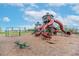 Community playground with large red slides, green climbing structures, and swings in a fenced area at 11606 Kilkenny Coral Dr, Riverview, FL 33579