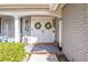 Inviting entryway with double doors adorned with wreaths, potted flowers, and brick accents at 12303 Fieldstone Ln, Hudson, FL 34667