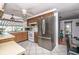 Bright kitchen featuring stainless steel refrigerator, white appliances, wood cabinets and white tile floor at 12303 Fieldstone Ln, Hudson, FL 34667