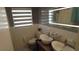 Bright bathroom features dual sinks, decorative lighting and window with modern shades at 12425 Ridge Rd, Largo, FL 33778