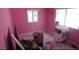 Unfurnished pink room with two windows and unorganized items on the floor at 12425 Ridge Rd, Largo, FL 33778